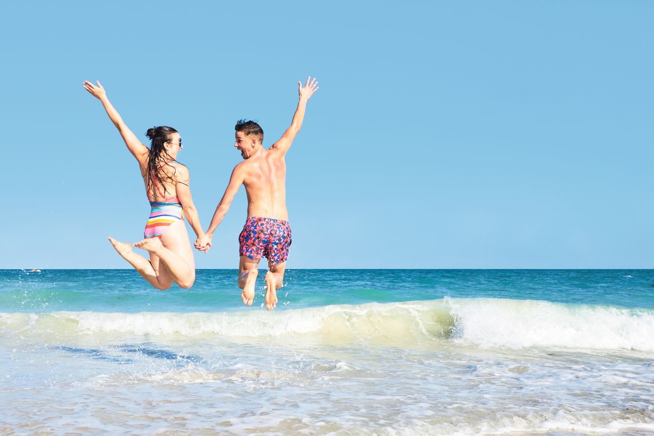 couple jumping in the sea